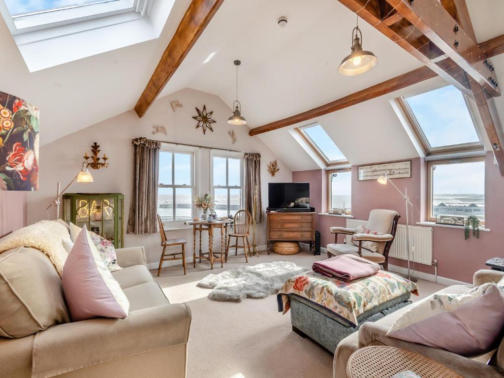 a living room with vaulted ceilings and windows at Ocean View in Lowestoft