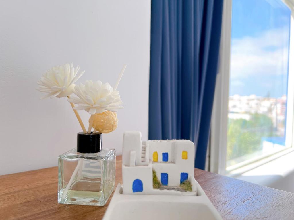 a table with a vase and a vase with flowers at Greek Frontier Villa in Magong