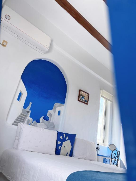 a bedroom with a white bed with a blue ceiling at Greek Frontier Villa in Magong