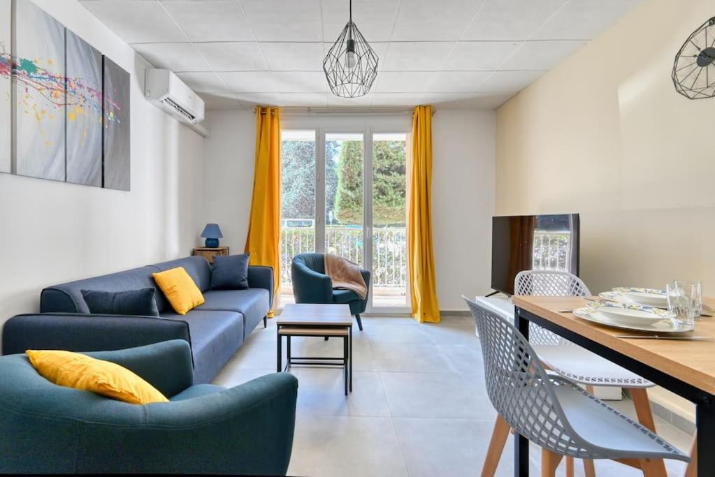 uma sala de estar com um sofá azul e cadeiras em Belle Vue - T5 rénové avec balcon et parking em Marselha