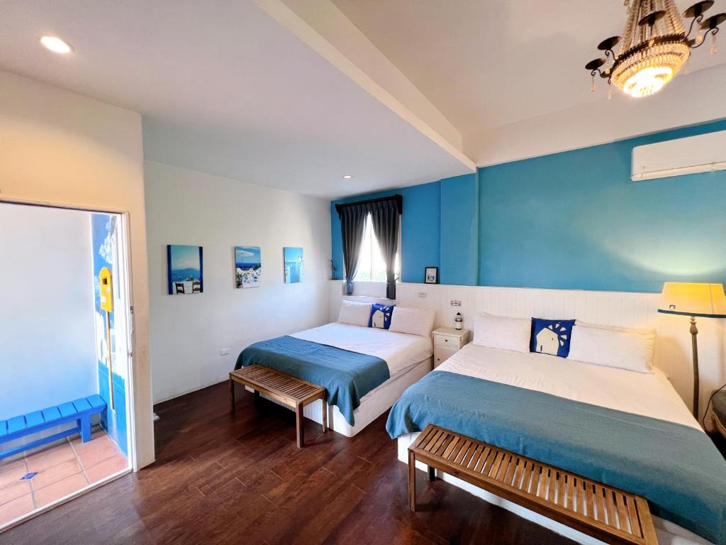two beds in a room with blue walls at Greek Frontier Villa in Magong