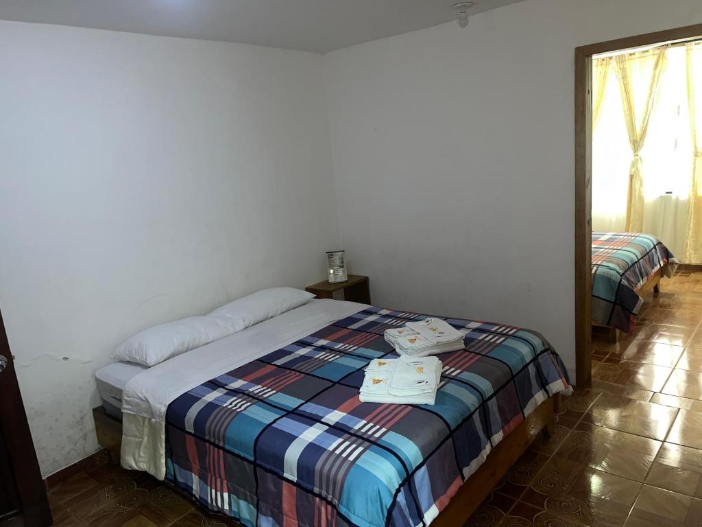 a bedroom with two beds in a room with a mirror at Hostal Don Viche in Mindo