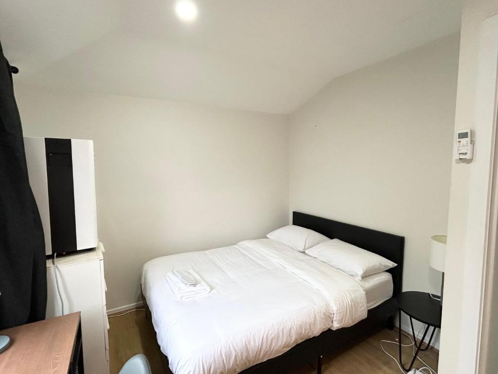 a bedroom with a bed with white sheets and a desk at 26 Gladstone Rd Highgate Hill in Brisbane