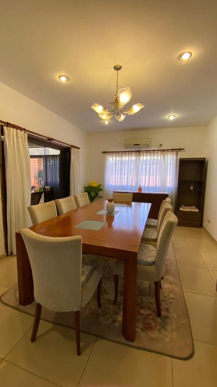 uma sala de jantar com uma mesa de madeira e cadeiras em Casa Hotel Confortable em Encarnación