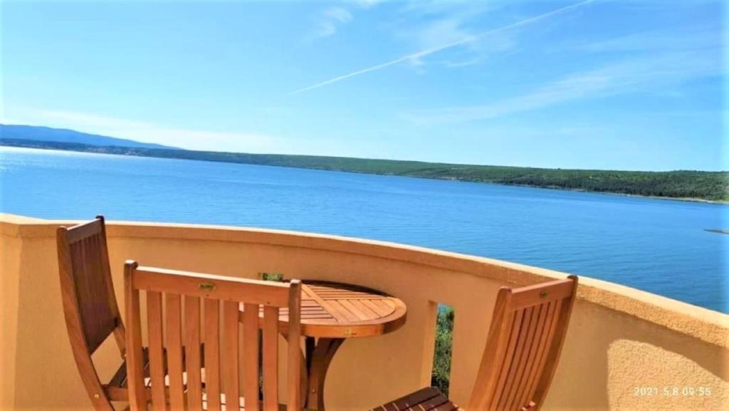 - Balcón con mesa y sillas y vistas al lago en Panoramic Sea View And 230m From The Beach, en Posedarje
