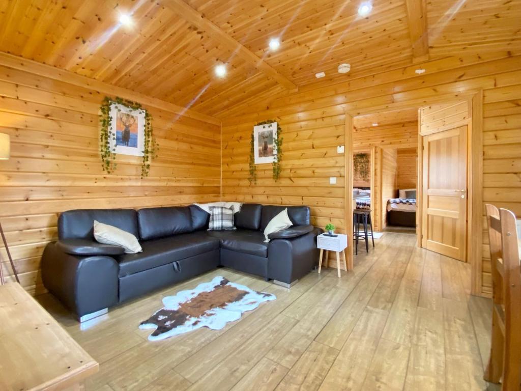 Magnolia Lodge-uk46280 في Camerton: غرفة معيشة مع أريكة زرقاء في غرفة خشبية