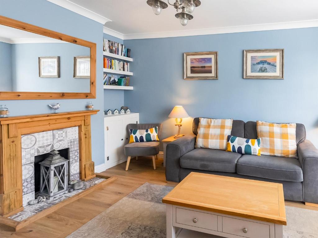 uma sala de estar com um sofá e uma lareira em Amelia House em Sheringham