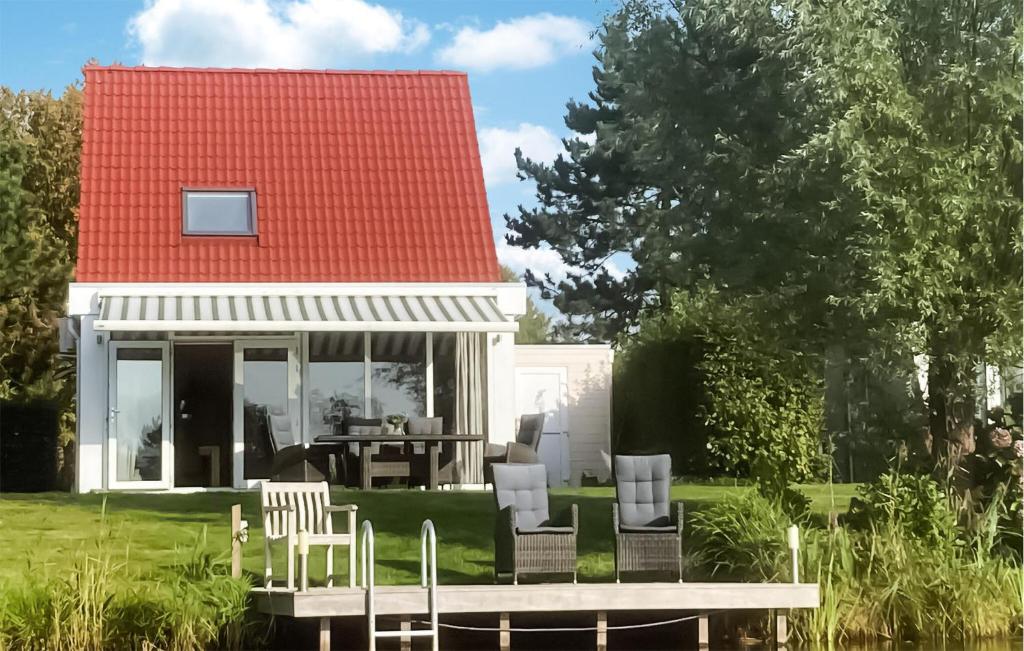 una casa con techo rojo, mesa y sillas en Amazing Home In Vlagtwedde With Indoor Swimming Pool, en Vlagtwedde