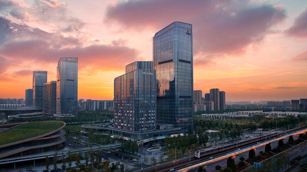 a city skyline with tall skyscrapers at sunset at Novotel Xi'an Aden in Xi'an