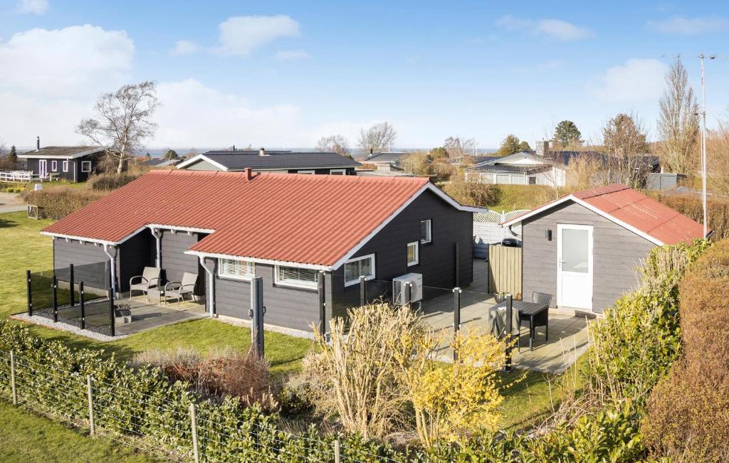 3 Bedroom Amazing Home In Bogense في بوجنسي: منزل أسود بسقف احمر