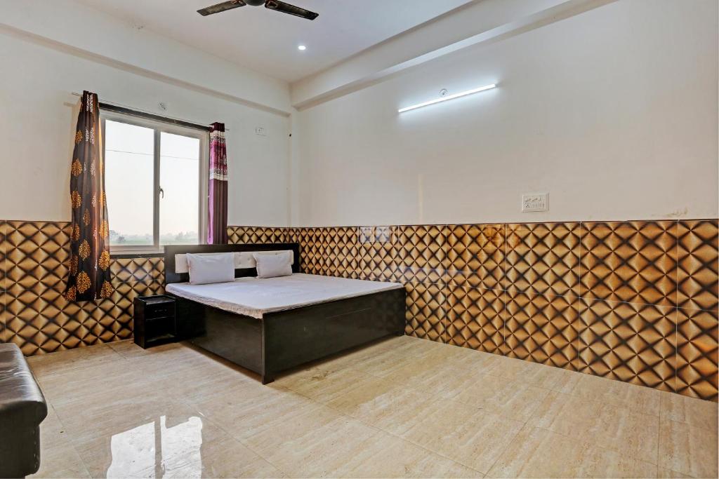 una stanza con un letto al centro di OYO S.R Group Of Hotel a Kānpur