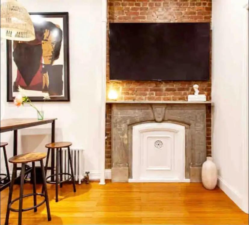 ein Wohnzimmer mit einem Kamin und einem TV darüber. in der Unterkunft Medina’s estate in Bronx