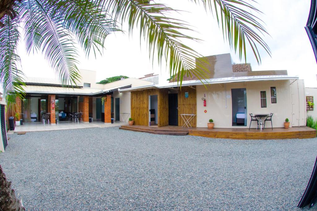 een huis met een binnenplaats en een palmboom bij Pousada Viva praia 30 metros da Praia in Penha