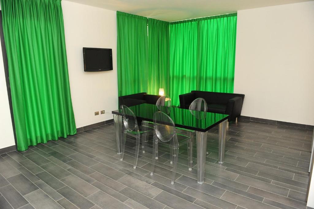 トリノにあるResidenza Menabreaのダイニングルーム(緑のカーテン、テーブル、椅子付)