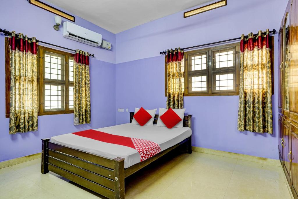 um quarto com uma cama com almofadas vermelhas em OYO Flagship Paradise villa em Cherai Beach