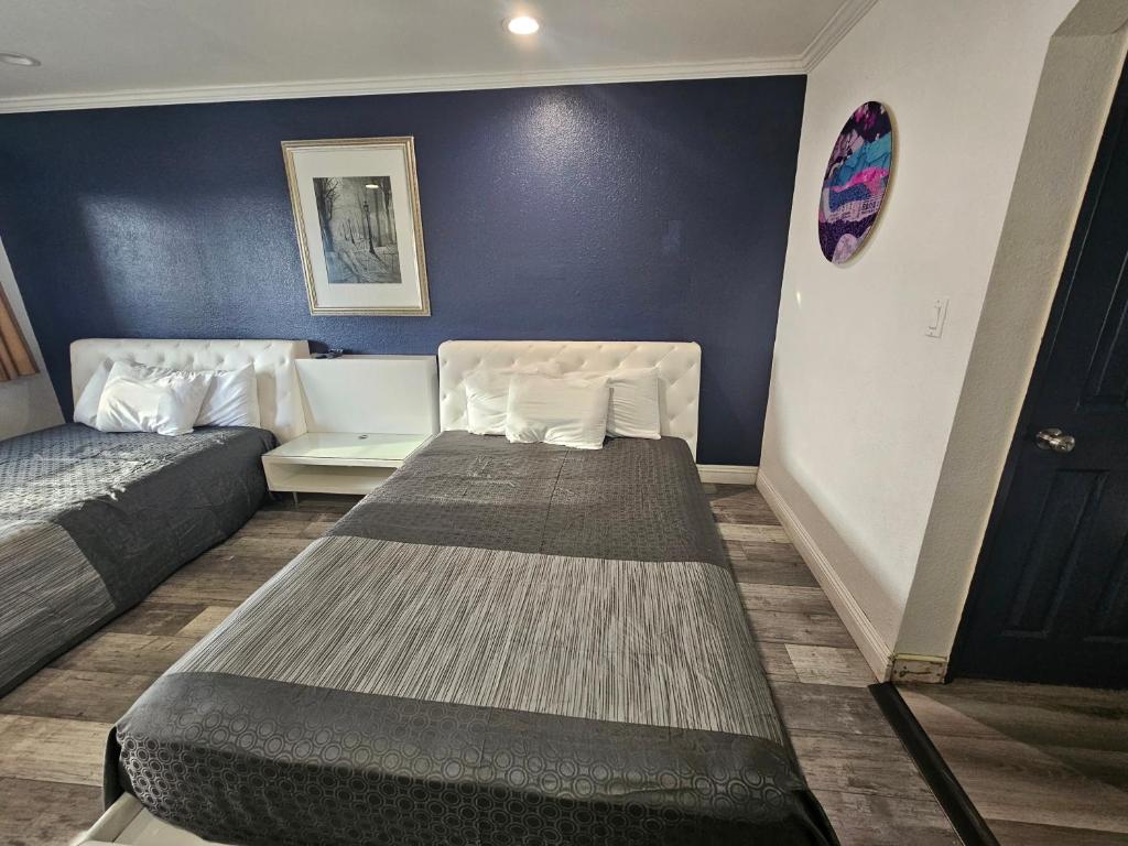 Zimmer mit 2 Betten und blauer Wand in der Unterkunft Flamingo Inn in Rosemead