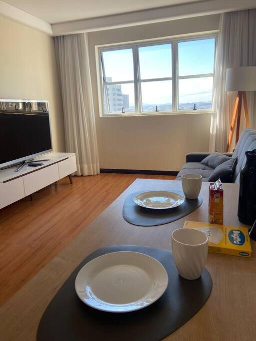 a living room with two tables with plates on it at Flat 1 qto, piscina, loc central in São José dos Pinhais