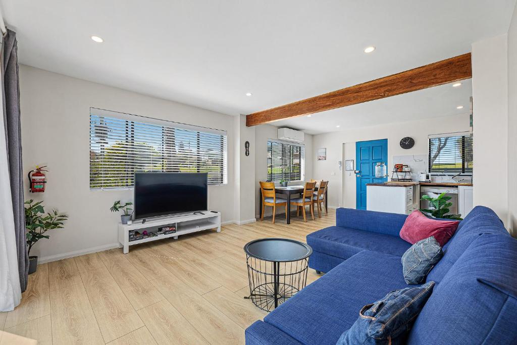 a living room with a blue couch and a tv at Paradise Retreat - relax & escape in Potato Point