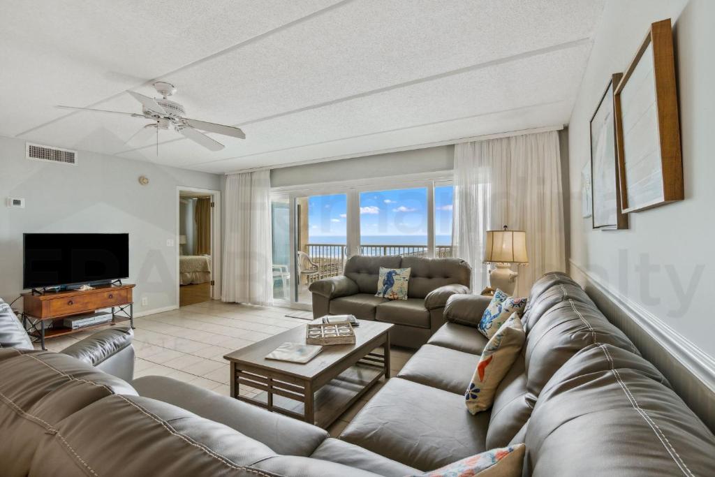 a living room with a couch and a television at Oceanfront Condo w Balcony in Amelia Island