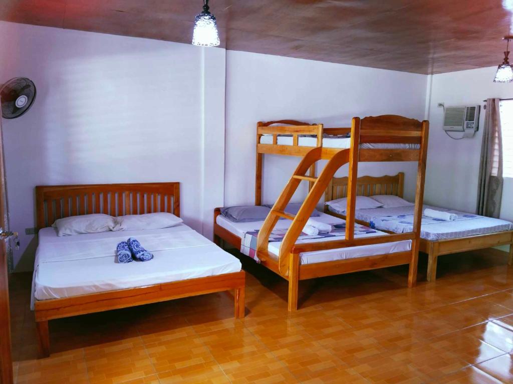 a room with two bunk beds and a bed at Casa James Apartment, Rooms , Pool and Restaurant in Siquijor