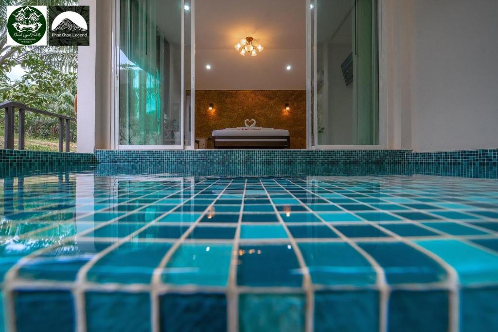 a swimming pool with a blue tile floor in a house at Khaosok Legend phase 2 in Khao Sok National Park