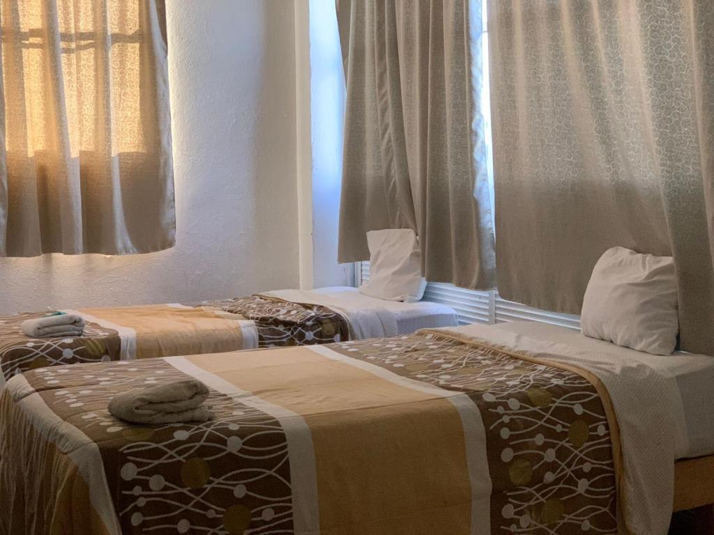 2 Betten nebeneinander in einem Zimmer in der Unterkunft HOTEL PUERTO REAL SUITES in Paraíso