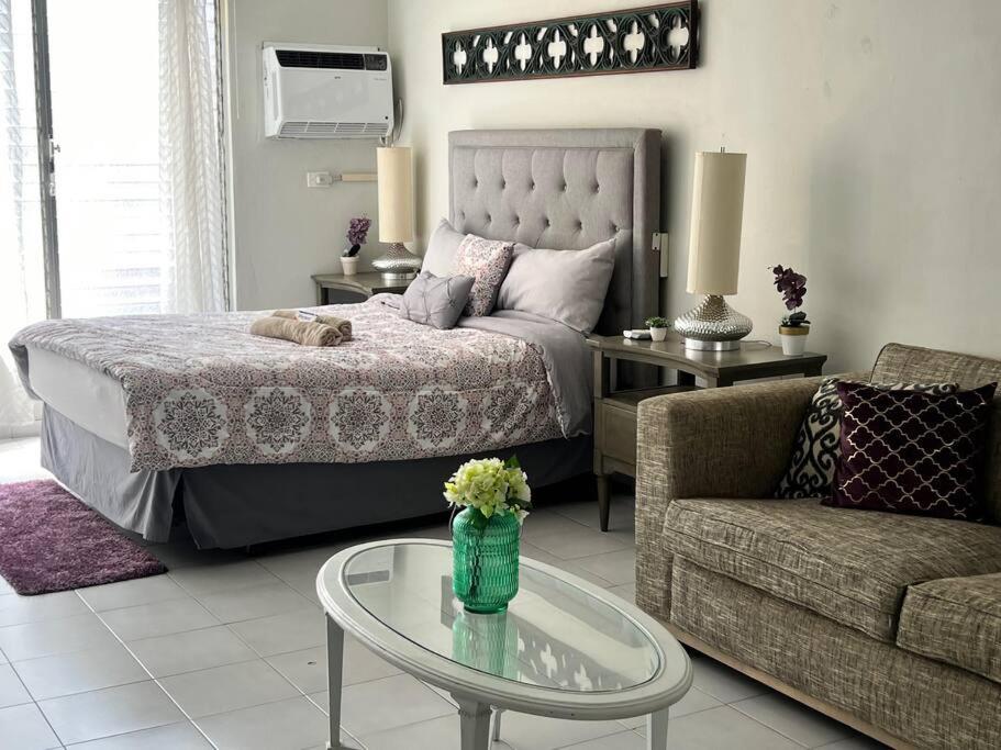 a bedroom with a bed and a couch and a table at Tranquil & Cozy Studio Near Tmobile District. in San Juan