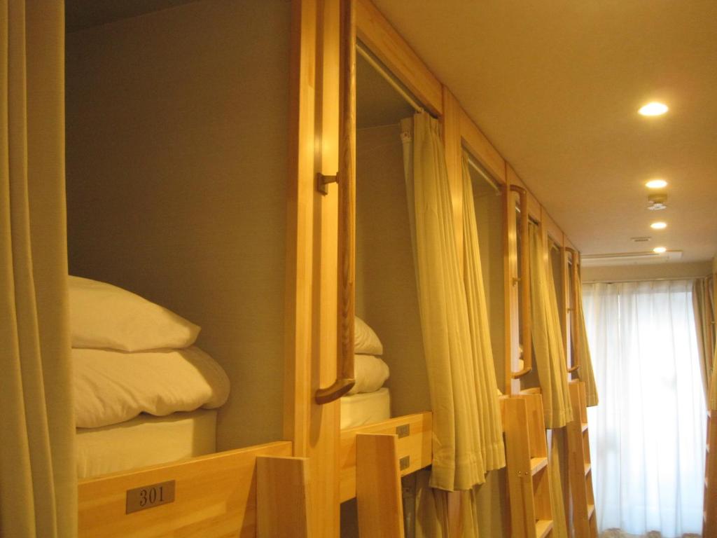 een kamer met een spiegel en enkele bedden bij HOTEL PRELE ホテル プレール in Tokyo
