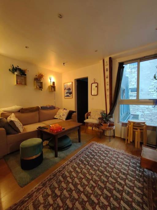 un salon avec un canapé et une table dans l'établissement Parfaite et confortable demeure, à Paris