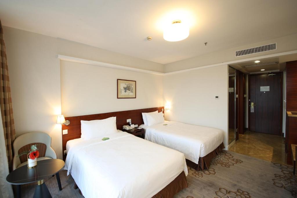 Postel nebo postele na pokoji v ubytování Liuhua Hotel