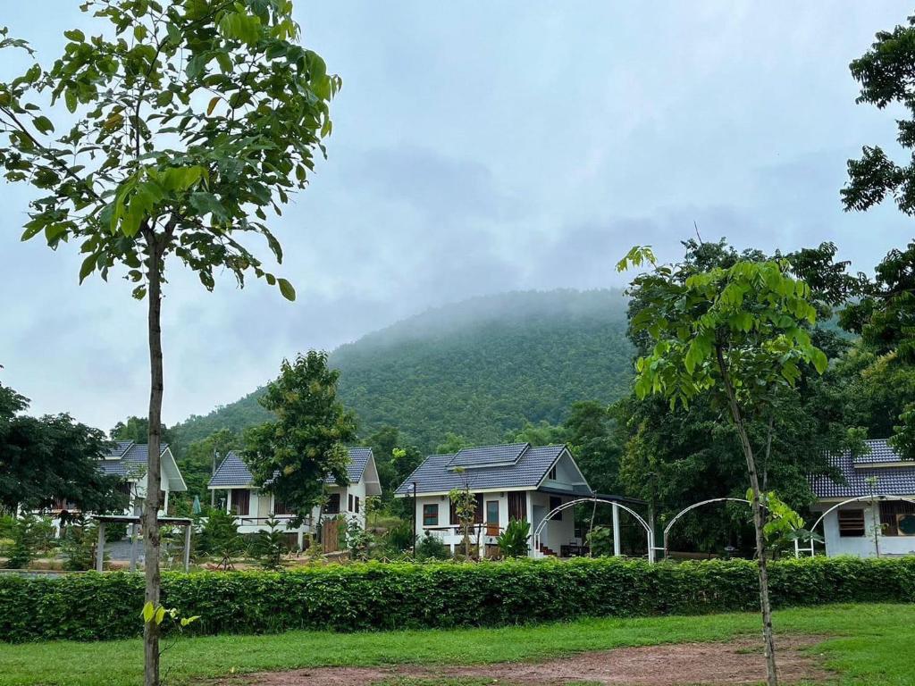 una fila de casas con una montaña en el fondo en พรพนาฮิลล์รีสอร์ท en Ban Makok