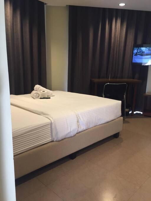 - une chambre avec un lit et un téléphone dans l'établissement Spacious Studio Apartment B203, à Manille