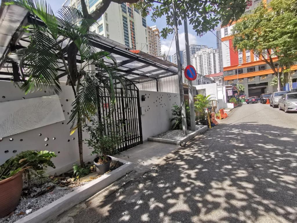 a street with a fence and trees and buildings at Autumn Guesthouse's near Jalan Alor Bukit Bintang in Kuala Lumpur