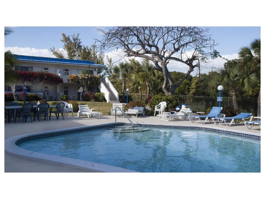 a swimming pool with chairs and tables and a house at Viceroy 101 in Freeport