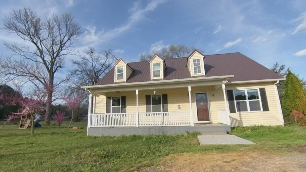 a white house with a brown roof at River Dream Lake Murray Getaway in Saluda