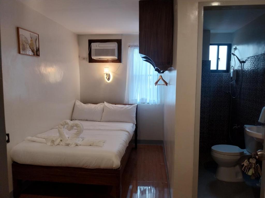 Habitación pequeña con cama y aseo en Belladama Hotel, en San Carlos