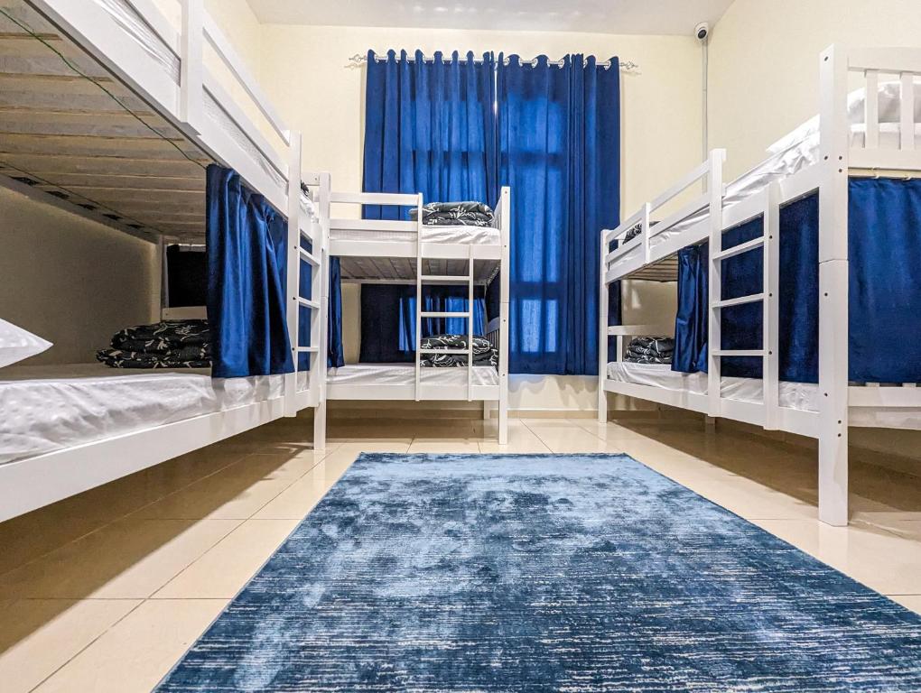 Habitación con 3 literas y alfombra. en Comfort Bed Inn en Dubái