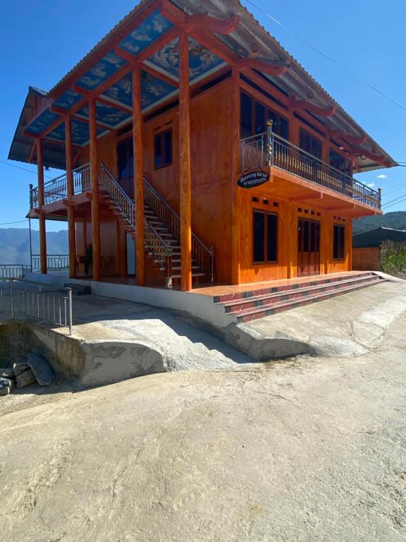 un edificio in legno con scale in cima a una montagna di Homestay Trúc Sơn a Hong Ha