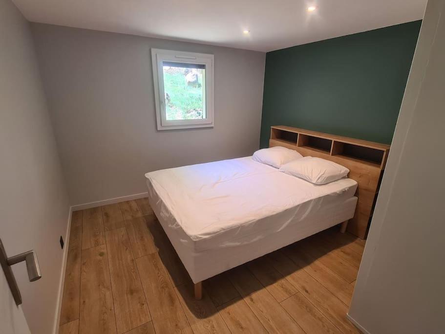 a bedroom with a white bed with a window at Chalet Le Parc de Latour, au pied de la montagne in Latour-de-Carol