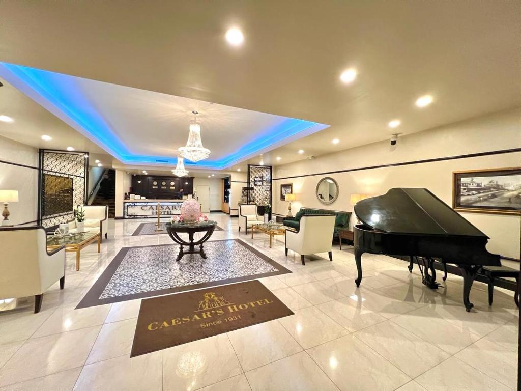 a living room with a piano and a dining area at Hotel Caesars in Tijuana