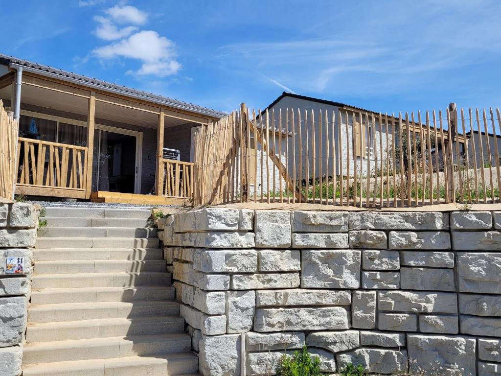 a stone retaining wall in front of a house at Chalet tranquille en Bretagne avec piscine chauffée, 2 chambres, proche mer et nature - FR-1-783-15 in Arzal