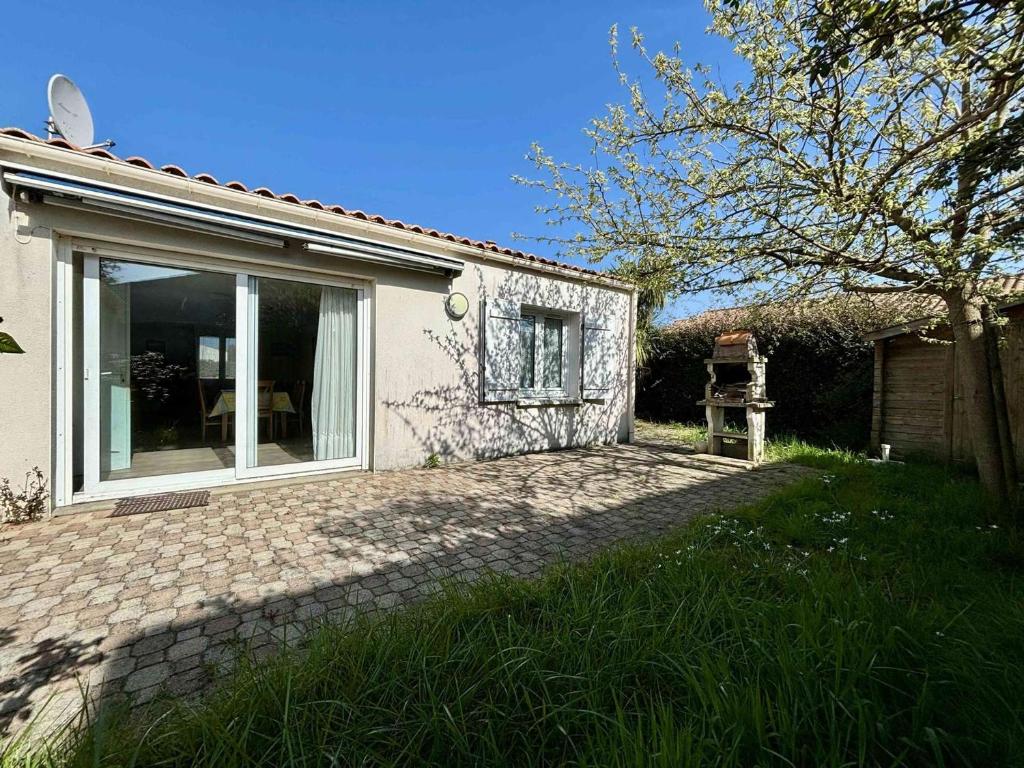 une maison avec une fenêtre sur le côté de celle-ci dans l'établissement Maison à La Cotinière, 6 couchages, proche port et plage, jardin, terrasse, parking privé - FR-1-246A-293, à Saint-Pierre-dʼOléron