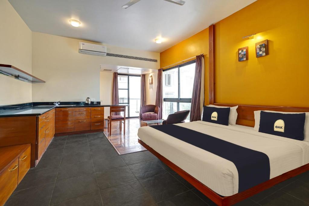 een slaapkamer met een bed, een bureau en een keuken bij Astra Hotels & Suites - Marathahalli in Bangalore