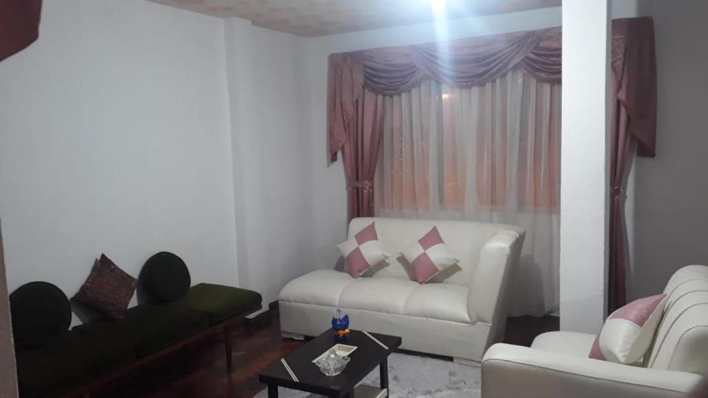 a living room with a couch and a chair at Apartamento en Miraflores in La Paz