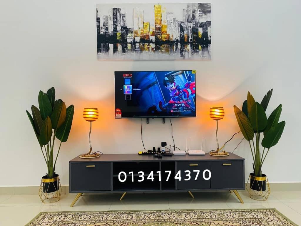 uma sala de estar com uma televisão de ecrã plano na parede em Alyn Home Kluang IV Netflix Wifi Coway em Keluang