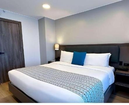 een slaapkamer met een groot bed met blauwe en witte kussens bij Nails spa niño robert in Quito
