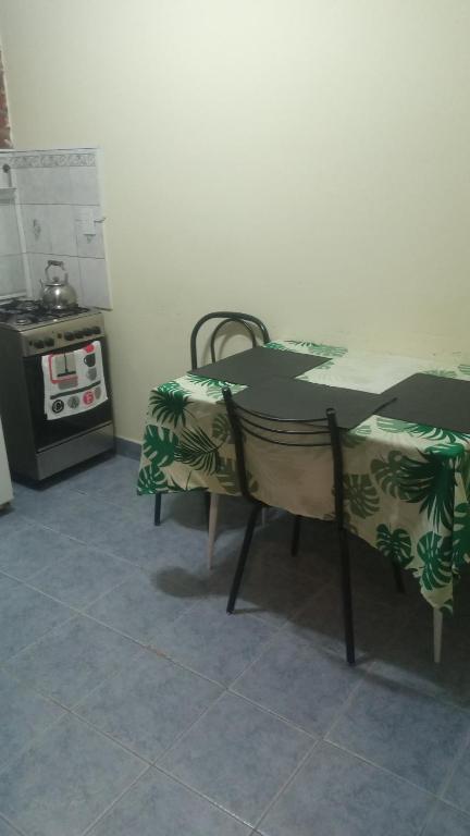 einen Tisch und Stühle in einer Küche mit Herd in der Unterkunft Departamentos PEUQUE in Comodoro Rivadavia