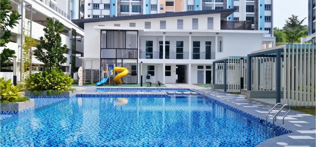 a swimming pool with a slide in front of a building at Bayu Temiang- Your Urban Retreat in Seremban