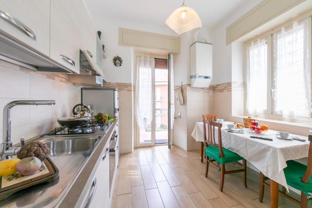 kuchnia ze zlewem i stołem z krzesłami w obiekcie Residenza La terrazza di Dante - Happy Rentals w mieście Stresa
