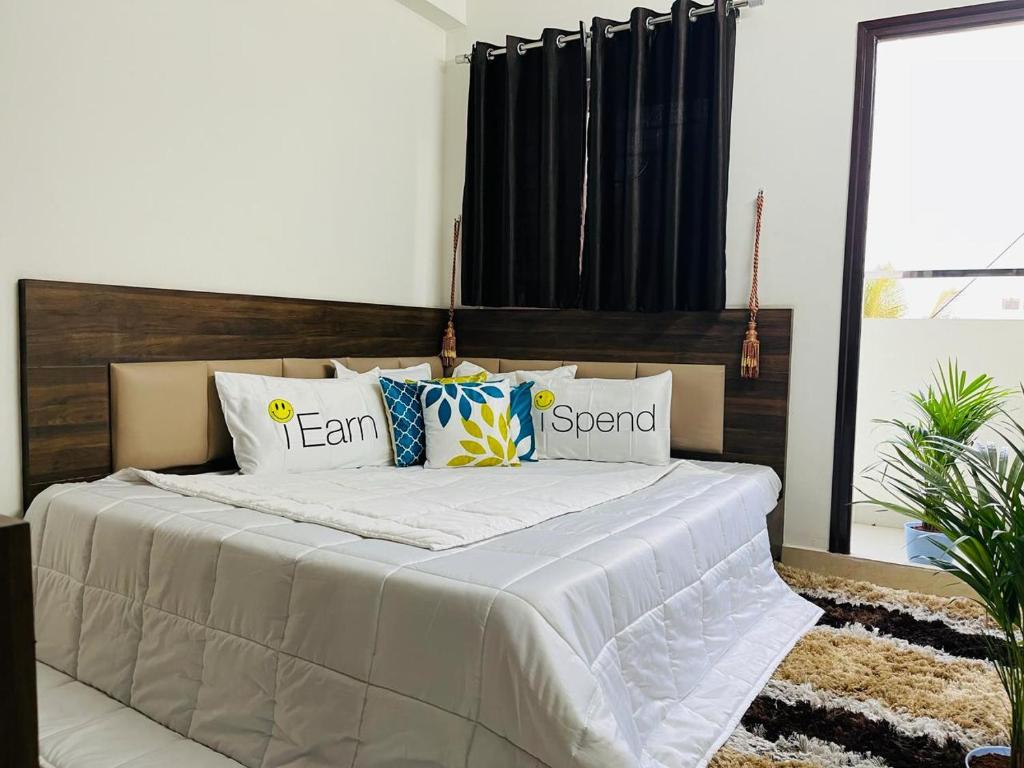 a bed with pillows on it in a bedroom at DivBnK homes Bangalore in Bangalore